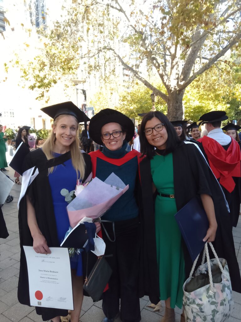 Jana and Ling Wen standing with Amy Salter, all in Academic robes.